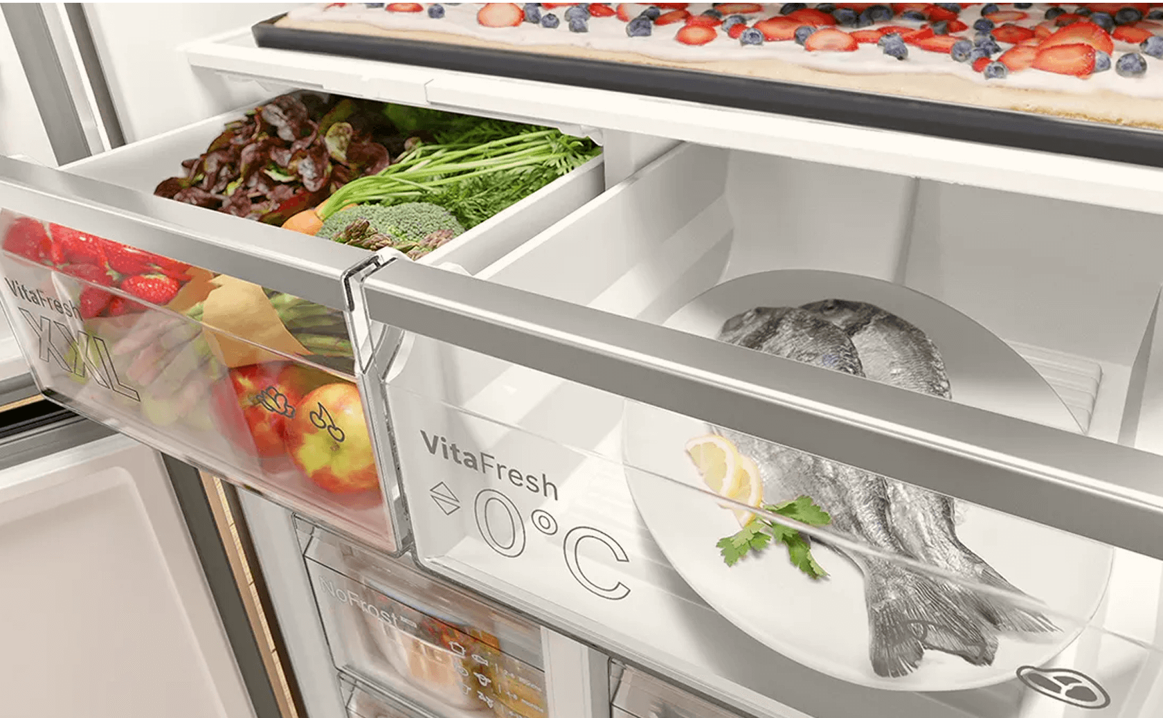 Zbliżenie na jedną z szuflad lodówki. Widoczne jedzenie: owoce, warzywa, ryby