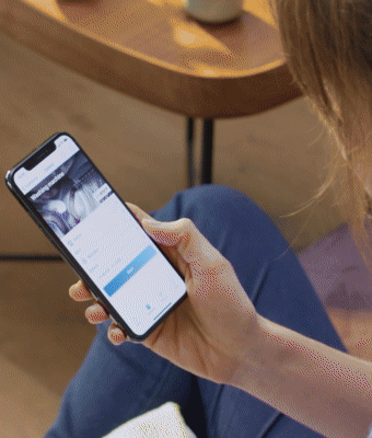 Animacja pokazuje jak osoba uruchamia pralkę z poziomu smartfona. Następnie widok na wnętrze pralki w trakcie prania